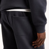 Detail einer Gesäßtasche einer dunkelblauen Jogginghose mit weißem Bund.