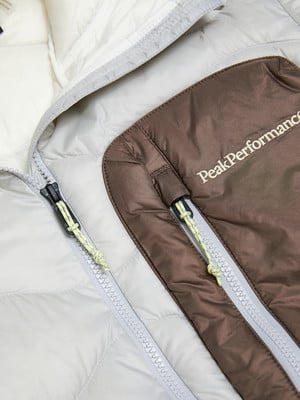 Detail einer Winterjacke mit Peak Performance Logo und Reißverschlüssen.