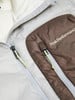 Detail einer Winterjacke mit Peak Performance Logo und Reißverschlüssen.