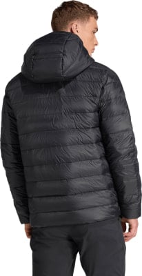 Ein Mann von hinten in einer schwarzen Daunenjacke mit Kapuze und dunkler Hose. Ein Mann von hinten in einer schwarzen Daunenjacke mit Kapuze und dunkler Hose.