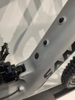Detail eines Mountainbike-Rahmens mit Dämpfer und Kratzer auf der Oberfläche. Detail eines Mountainbike-Rahmens mit Dämpfer und Kratzer auf der Oberfläche.