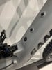 Detail eines Mountainbike-Rahmens mit Dämpfer und Kratzer auf der Oberfläche.