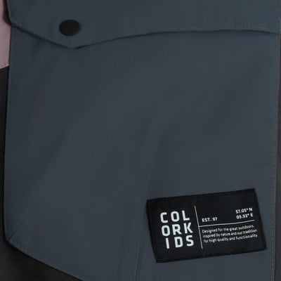 Stoffdetail mit Tasche und schwarzem Aufnäher mit Logo und Text. Stoffdetail mit Tasche und schwarzem Aufnäher mit Logo und Text.