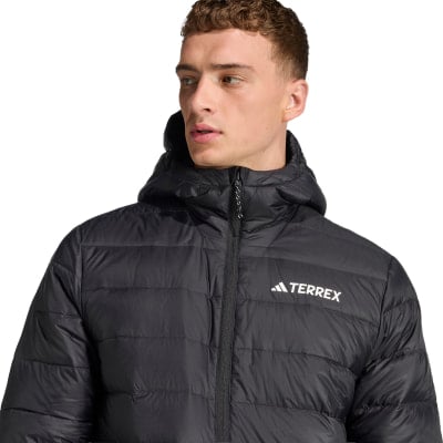 Ein Mann in einer schwarzen Daunenjacke mit Terrex-Logo auf der Brust. Ein Mann in einer schwarzen Daunenjacke mit Terrex-Logo auf der Brust.