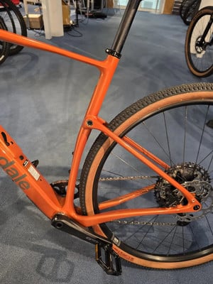 Ein orangefarbenes Fahrrad mit braunen Reifen und schwarzer Sattelstütze. Ein orangefarbenes Fahrrad mit braunen Reifen und schwarzer Sattelstütze.