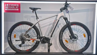 Silbernes Genesis E-Bike mit schwarzen Details und Logo auf dem Rahmen. Silbernes Genesis E-Bike mit schwarzen Details und Logo auf dem Rahmen.