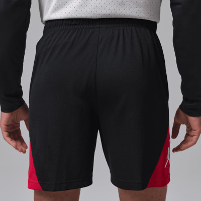 Schwarze Shorts mit roten Seiteneinsätzen und Jordan-Logo. Schwarze Shorts mit roten Seiteneinsätzen und Jordan-Logo.