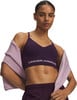 Frau in einem dunkelvioletten Sport-BH mit Under Armour Schriftzug.