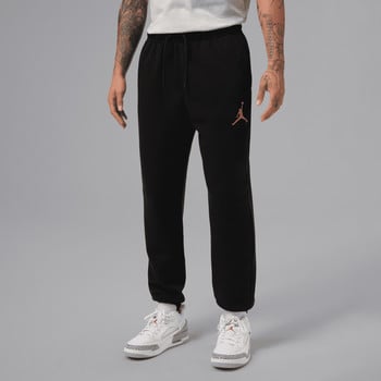 Mann in schwarzer Jogginghose mit Jordan-Logo und weißen Turnschuhen
