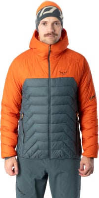 Ein Mann in einer orange-grauen Daunenjacke und Mütze blickt nach vorn.