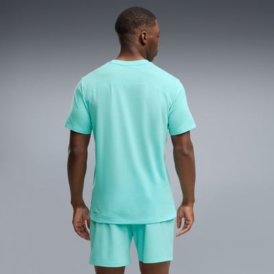 Ein Mann in einem türkisfarbenen T-Shirt und Shorts von hinten. Ein Mann in einem türkisfarbenen T-Shirt und Shorts von hinten.