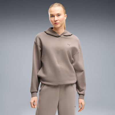 Frau in einem beigen Kapuzenpullover und Jogginghose. Frau in einem beigen Kapuzenpullover und Jogginghose.