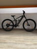 Schwarzes Mountain-E-Bike mit Federung und Scheibenbremsen auf Holzboden.