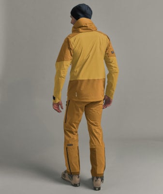 Ein Mann in Skibekleidung, von hinten gesehen, vor neutralem Hintergrund. Ein Mann in Skibekleidung, von hinten gesehen, vor neutralem Hintergrund.
