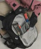 Eine Person mit Handschuhen verstaut Schaufel und Lawinensonden im Rucksack.