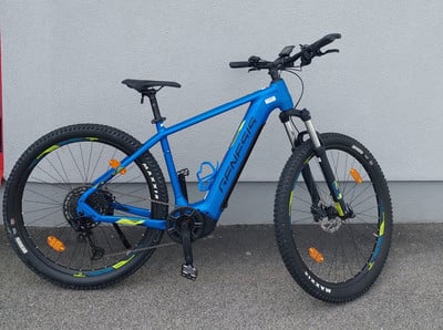 Ein blaues Genesis E-Mountainbike mit schwarzen Reifen und gelben Akzenten. Ein blaues Genesis E-Mountainbike mit schwarzen Reifen und gelben Akzenten.