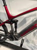 Detail des hinteren Teils eines rot-grauen E-Bikes mit Dämpfer und Antrieb.