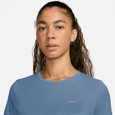 Mädchen in blauem T-Shirt mit Nike-Logo auf der Brust