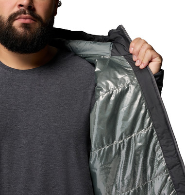 Ein Mann in einem dunklen T-Shirt schließt eine schwarze Jacke mit reflektierendem Futter. Ein Mann in einem dunklen T-Shirt schließt eine schwarze Jacke mit reflektierendem Futter.