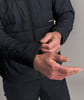 Detail einer Jacke, bei der ein Mann den Ärmel zurechtrückt.