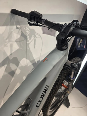 Detailaufnahme eines grauen Cube Mountainbikes mit schwarzen Schriftzügen. Detailaufnahme eines grauen Cube Mountainbikes mit schwarzen Schriftzügen.