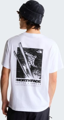 Ein Mann trägt ein weißes T-Shirt mit einem Skifahrer-Druck und dem The North Face-Logo.