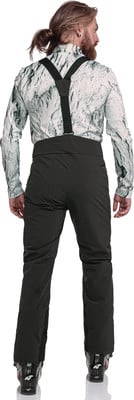 Mann in Skibekleidung, Rückseite mit Bergprint und schwarzer Hose. Mann in Skibekleidung, Rückseite mit Bergprint und schwarzer Hose.
