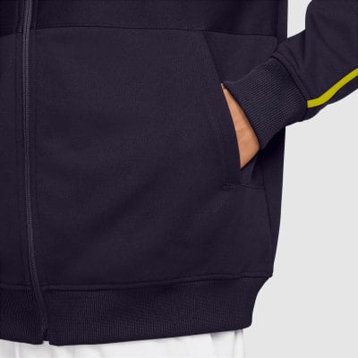Detail einer dunkelblauen Jacke mit Tasche und gelbem Streifen am Ärmel. Detail einer dunkelblauen Jacke mit Tasche und gelbem Streifen am Ärmel.