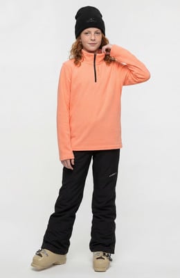 Mädchen in einem orangefarbenen Pullover und schwarzer Skihose mit Skischuhen. Mädchen in einem orangefarbenen Pullover und schwarzer Skihose mit Skischuhen.