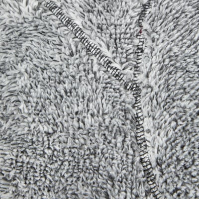Detail flauschigen grauen Stoffes mit sichtbaren Nähten und Reißverschluss. Detail flauschigen grauen Stoffes mit sichtbaren Nähten und Reißverschluss.