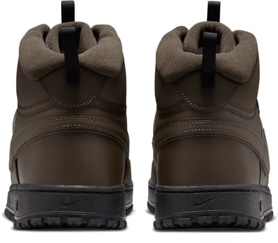 Rückansicht eines Paares dunkelgrüner Nike Knöchel-Stiefel. Rückansicht eines Paares dunkelgrüner Nike Knöchel-Stiefel.