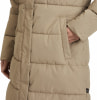 Detail einer Damen-Steppjacke in Beige mit einer Tasche, in die eine Hand gesteckt ist.