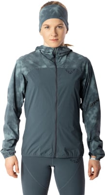 Frau in dunkler Jacke mit Muster und Stirnband mit Dynafit-Logo. Frau in dunkler Jacke mit Muster und Stirnband mit Dynafit-Logo.