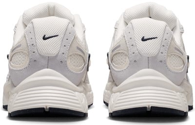 Fehér Nike cipők párjának hátulnézete, saroklogóval. Fehér Nike cipők párjának hátulnézete, saroklogóval.