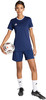 Eine Frau im dunkelblauen Fußball-Outfit hält einen Fußball.