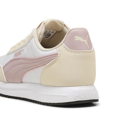 Közeli kép fehér Puma tornacipők hátuljáról rózsaszín csíkokkal. Közeli kép fehér Puma tornacipők hátuljáról rózsaszín csíkokkal.