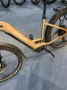 Detail eines Haibike E-Bikes mit goldenem Rahmen und schwarzen Rädern auf blauem Teppich.