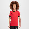 Junge in einem roten T-Shirt mit schwarzem Saum und weißem Nike-Logo.