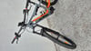 Graues KTM E-Bike mit orangefarbenen Details auf gepflastertem Untergrund.