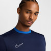 Mann in dunkelblauem T-Shirt mit Nike-Logo und blauem Kragen.