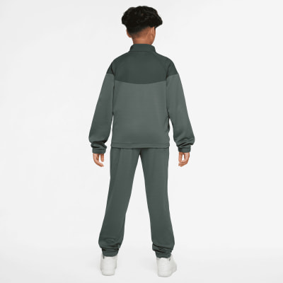Rückansicht eines Jungen in einem dunkelgrünen Nike Trainingsanzug.