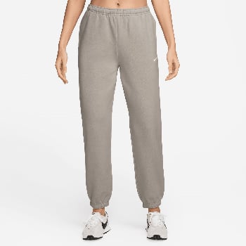 Graue Nike Jogginghose für Damen mit Logo am Oberschenkel und weißen Sneakern.