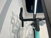 Detail eines Fahrradlenkers mit schwarzem Lenkerband und Vorbau.
