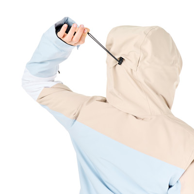 Nahaufnahme einer Jacke mit Kapuze, die eine Person mit einem Kordelzug enger zieht. Nahaufnahme einer Jacke mit Kapuze, die eine Person mit einem Kordelzug enger zieht.