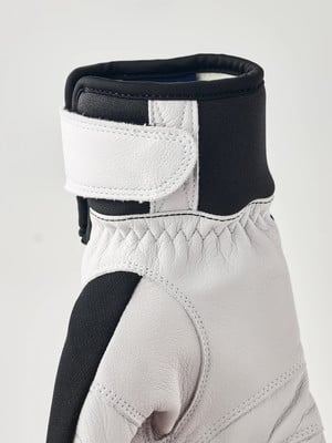 Nahaufnahme eines Handschuhs mit weißem Klettverschluss und schwarzen Elementen. Nahaufnahme eines Handschuhs mit weißem Klettverschluss und schwarzen Elementen.