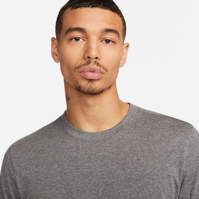 Ein Mann in einem grauen Rundhals-T-Shirt mit kurzem Haarschnitt. Ein Mann in einem grauen Rundhals-T-Shirt mit kurzem Haarschnitt.
