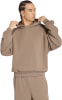 Ein Mann in einem braunen Hoodie und einer Jogginghose mit Adidas-Logo.