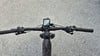 Lenker eines E-Bikes mit Display und Griffen auf Asphalt.