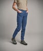 Mann in beigem Hemd und blauer Hose mit Schuhen.