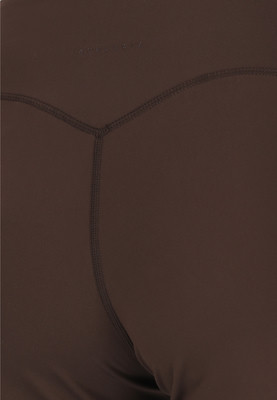 Detail der Rückseite einer dunkelbraunen Leggings mit Nähten. Detail der Rückseite einer dunkelbraunen Leggings mit Nähten.
